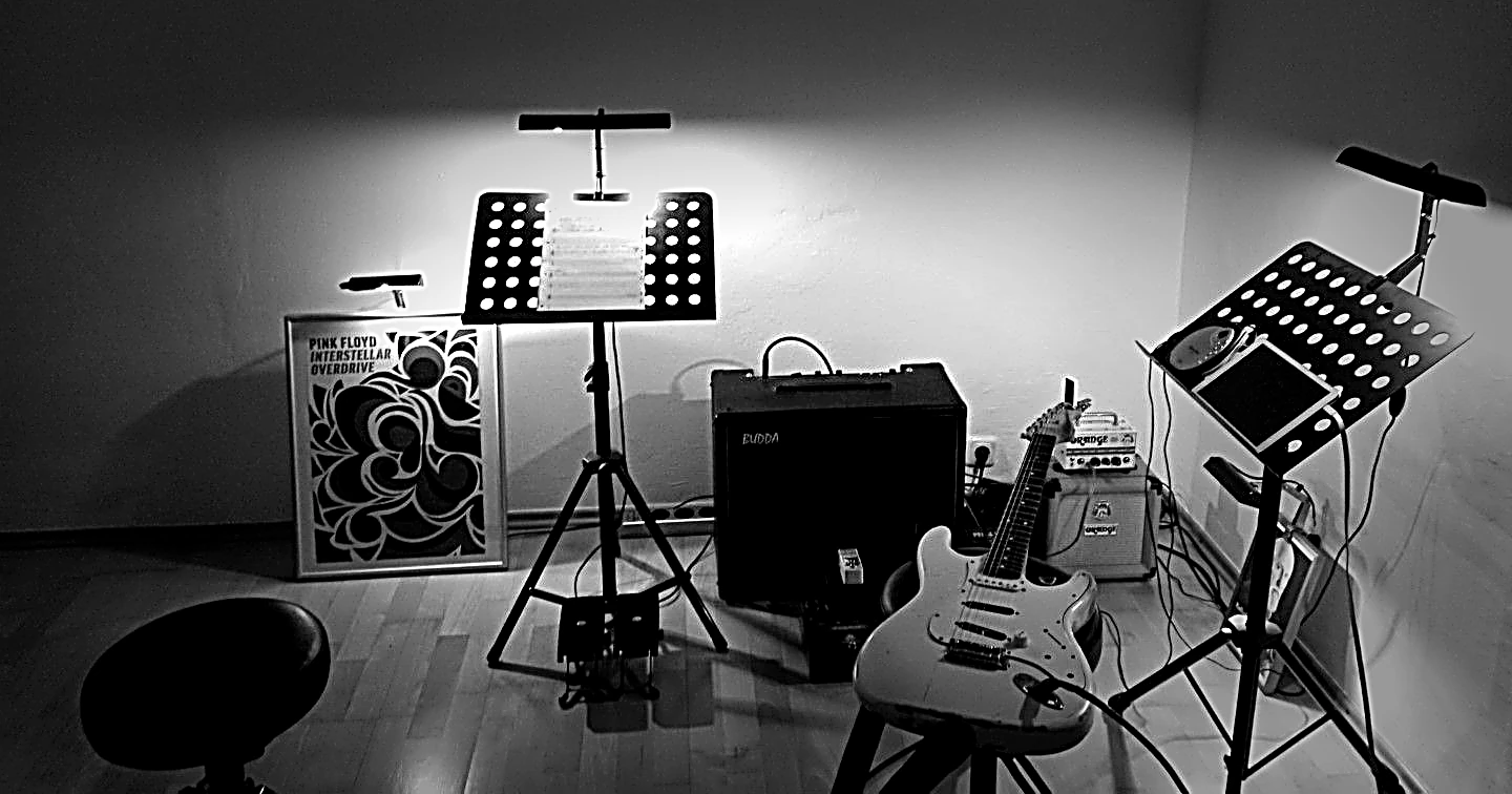Unterrichtsraum mit Notenständern, Verstärkern und Gitarre